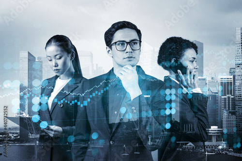 Group of business colleagues working on new venture capital and hi-tech start up and try to forecast risks and estimate prospective earning growth. Hologram chart on Singapore background.