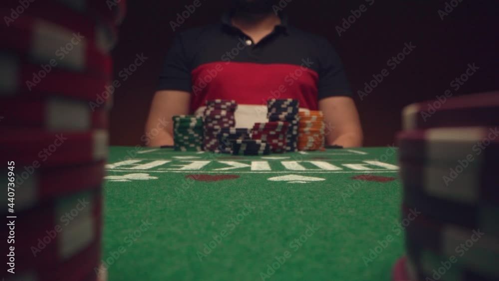 Male player betting all chips in while playing in casino, close up