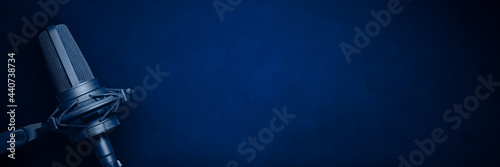 Blue podcast microphone background with copy space