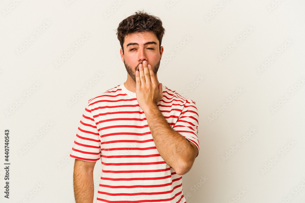 Young caucasian man isolated on white background yawning showing a tired gesture covering mouth with hand. Young caucasian man isolated on white background yawning showing a tired gesture covering mouth with hand.