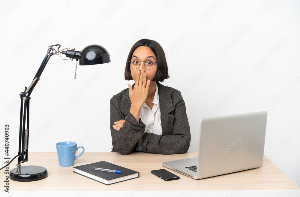 Young business mixed race woman working at office covering mouth with hand Young business mixed race woman working at office covering mouth with hand