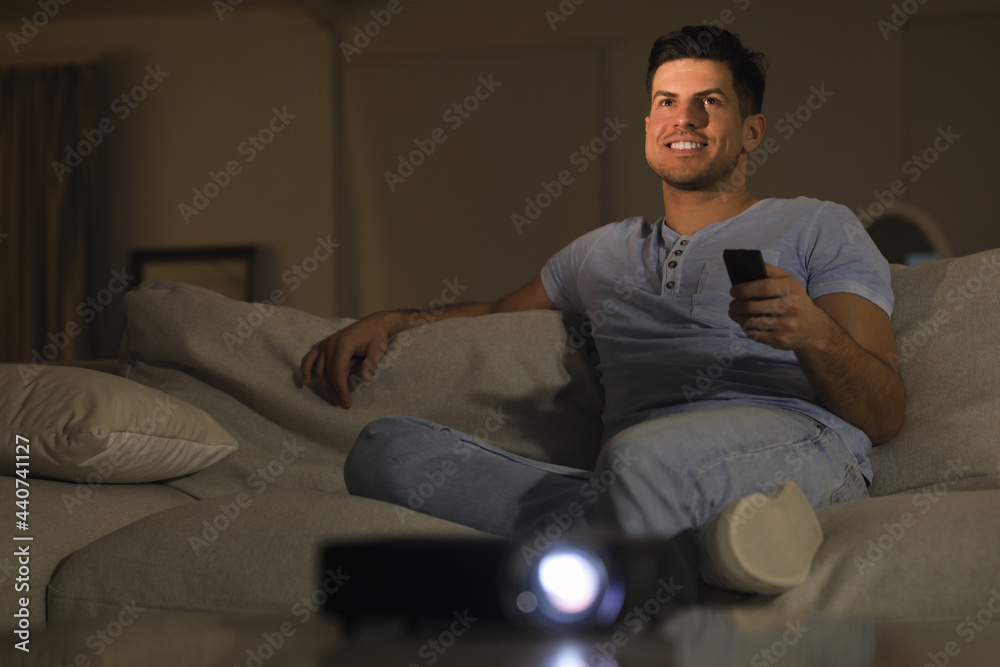 Man watching movie on sofa at night, space for text