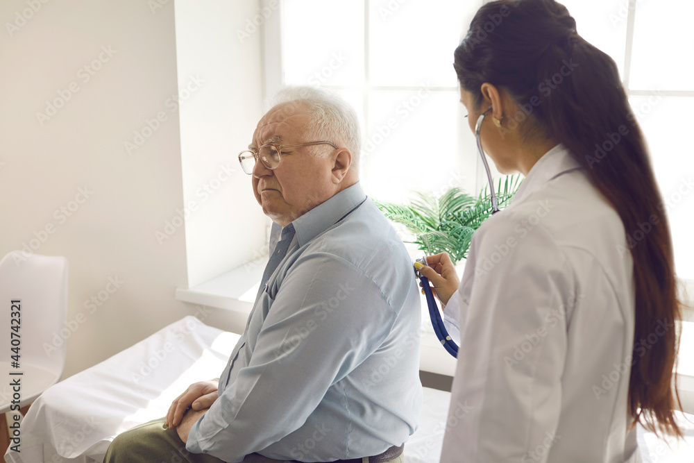 © Studio Romantic - Female doctor examining elderly male patient by stethoscope at hospital ward. Physician listening breath conducting lung test. Coronavirus flu medical checkup, old people medical health insurance © Studio Romantic - Female doctor examining elderly male patient by stethoscope at hospital ward. Physician listening breath conducting lung test. Coronavirus flu medical checkup, old people medical health insurance