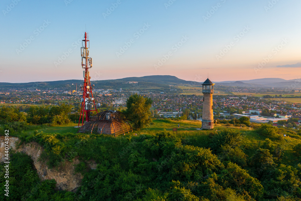 Obraz premium Beautiful aerial sunset landscape about Strazsa Hill with lookout tower which is located near Esztergom, in the Pilis Mountains. Dorog city at the background.