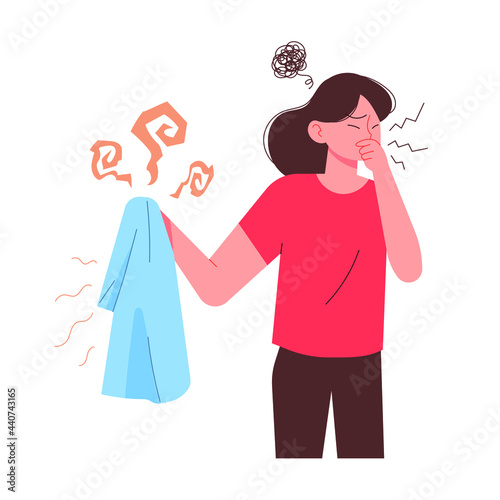 Woman holding sweaty smelly t-shirt and dislike. Bad smell of summer laundry.