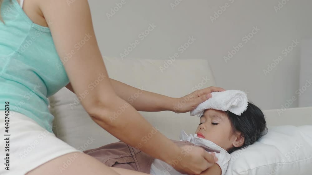 Asian Mother comforting her unwell daughter from a influenza illness Asian Mother comforting her unwell daughter from a influenza illness