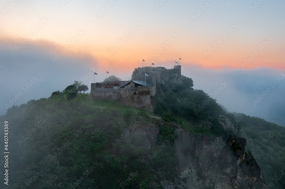 Aerial view abour castle of Sirok with misty matra mountains at the background. Spring sunrise landscape.