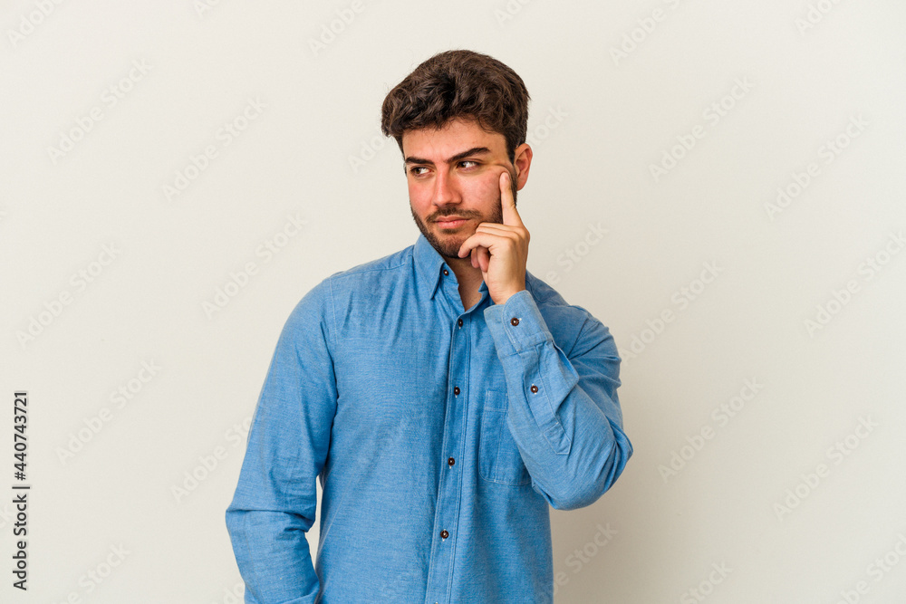 Young caucasian man isolated on white background contemplating, planning a strategy, thinking about the way of a business. Young caucasian man isolated on white background contemplating, planning a strategy, thinking about the way of a business.