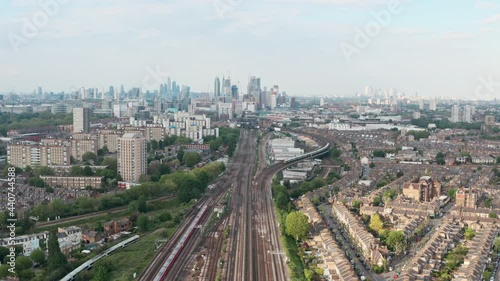 dolly forward drone shot of busy British rail train tracks towards London city centre photo
