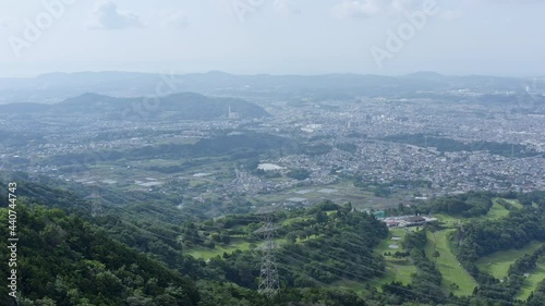 Looking down from hadano mountains to the nearby city. Breath-taking drone shot of nature and urban settlement. photo