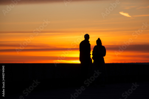 People figures on the sunset background on the beach