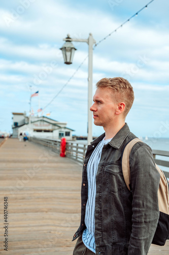 A young man stands on a pier in Santa Barbara, California, USA