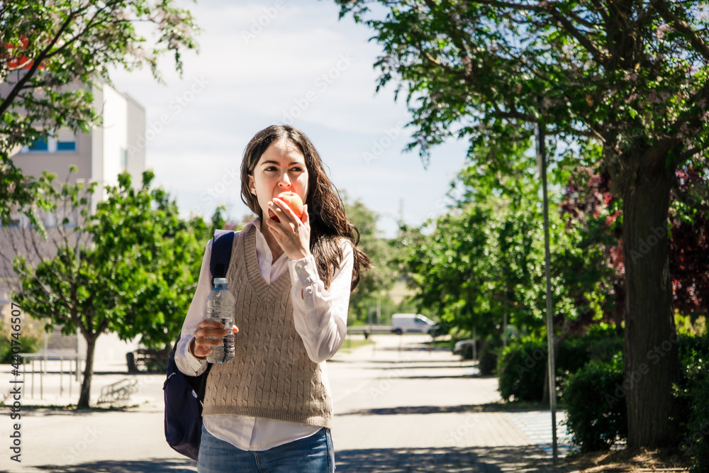 College girl eating an apple in campus. Back to college College girl eating an apple in campus. Back to college