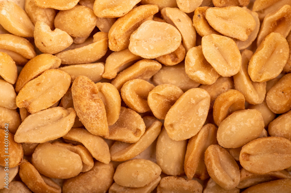 Roasted salted peanuts, surface texture. Close-up, selective focus. Roasted salted peanuts, surface texture. Close-up, selective focus.