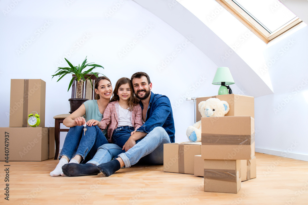 Portrait of happy smiling caucasian family being in their new house and cardboard boxes around them. Portrait of happy smiling caucasian family being in their new house and cardboard boxes around them.