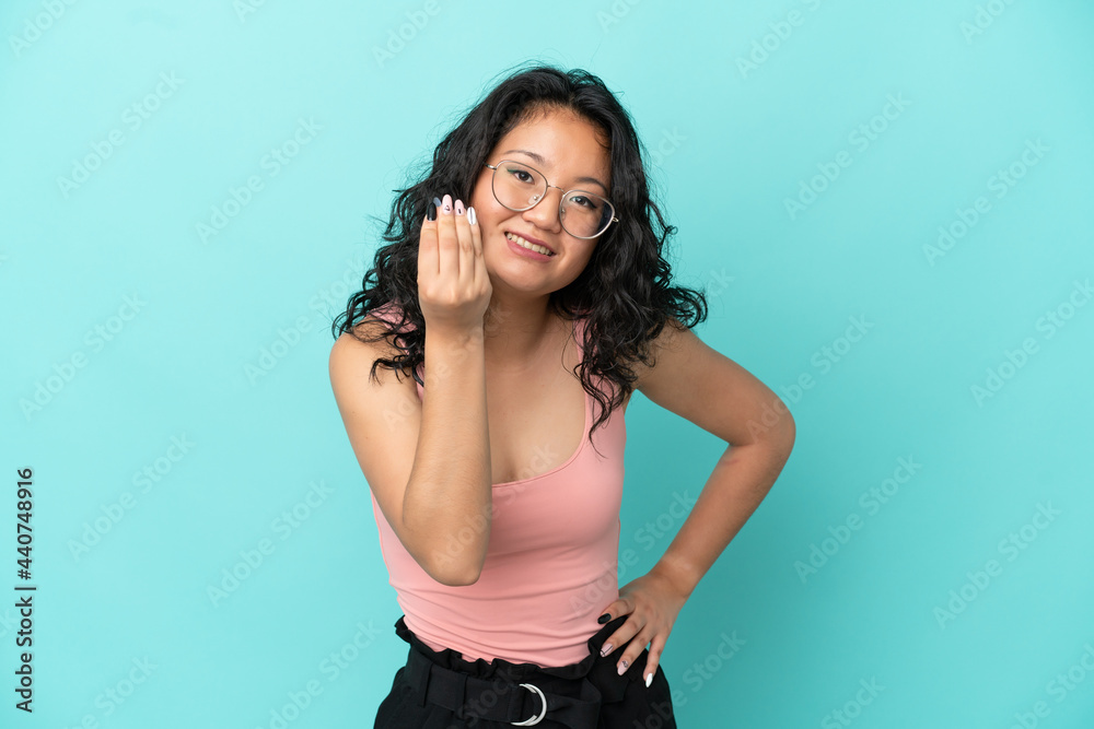 Young asian woman isolated on blue background making Italian gesture Young asian woman isolated on blue background making Italian gesture