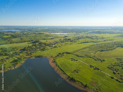 Beautiful aerial landscape on lake village with drone. Many lake islands covered with forests, fields on a sunny day