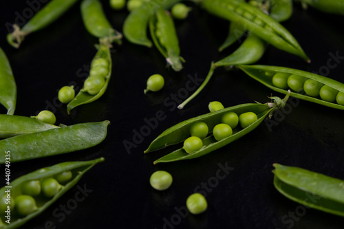green peas in pods on a black background