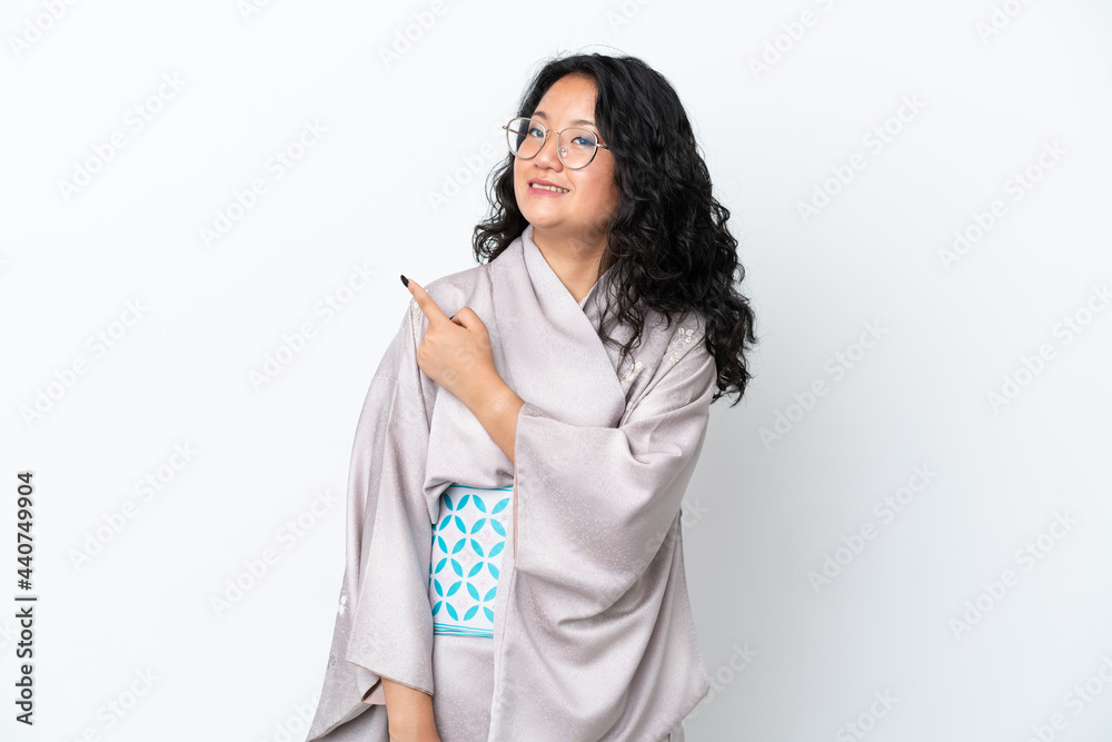 Young asian woman wearing kimono isolated on white background pointing to the side to present a product Young asian woman wearing kimono isolated on white background pointing to the side to present a product