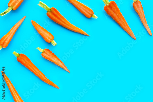 Fresh carrots on blue background.