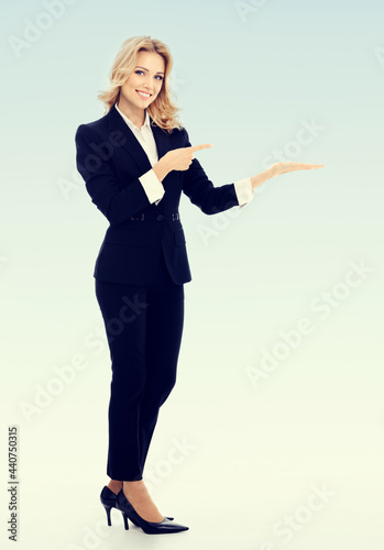 Portrait of happy smiling businesswoman, showing something or blank copyspace area for slogan or text message. Success in business, job and education concept.