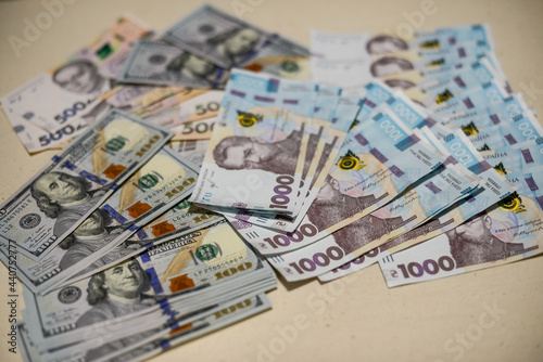 banknotes of dollars and hryvnia are laid out on a white background 