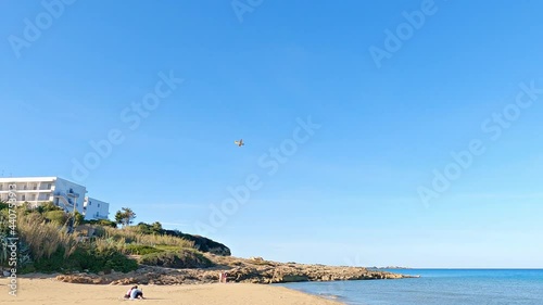 A Canadair firefighter flying above the Eloro beach on a sunny day in Sicily, Italy shot in 4K photo