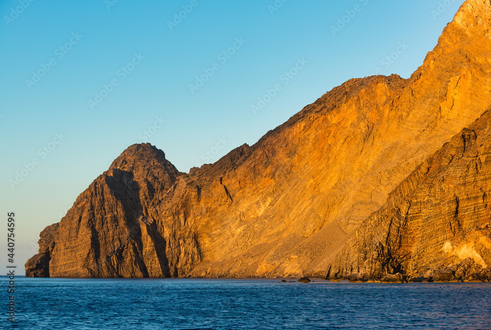Naklejka premium Warm dawn light illuminates the rocks of the south coast of the Greek island of Kassos in the Dodecanese archipelago