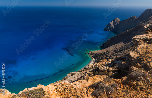Beach at the base of the rocky walls of the south coast of the Greek island of Kassos in the Dodecanese archipelago