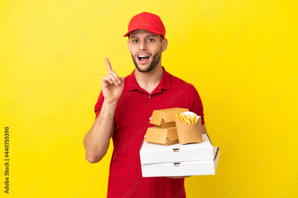 pizza delivery man picking up pizza boxes and burgers over isolated background intending to realizes the solution while lifting a finger up pizza delivery man picking up pizza boxes and burgers over isolated background intending to realizes the solution while lifting a finger up