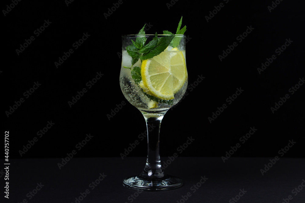 Refreshing cocktail with ice, lemon and mint on a black background. Non-alcoholic cocktail. Refreshing cocktail with ice, lemon and mint on a black background. Non-alcoholic cocktail.