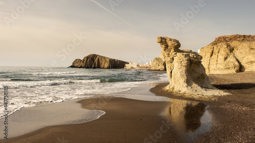 Playa en cabo de gata con reflejos de una roca en la arena