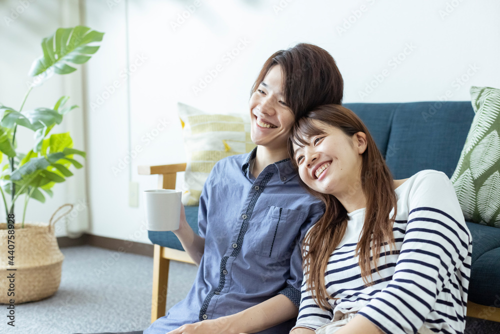 リビングでくつろぐ仲の良い日本人の男女 リビングでくつろぐ仲の良い日本人の男女