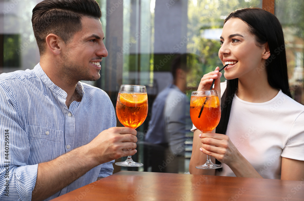 Happy couple with Aperol spritz cocktails outdoors Happy couple with Aperol spritz cocktails outdoors