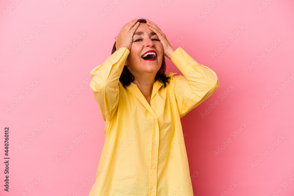 Middle age caucasian woman isolated on pink background laughs joyfully keeping hands on head. Happiness concept. Middle age caucasian woman isolated on pink background laughs joyfully keeping hands on head. Happiness concept.