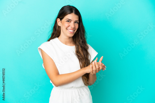 Young caucasian woman isolated on blue background applauding