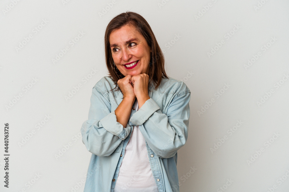 Middle age caucasian woman isolated on white background keeps hands under chin, is looking happily aside. Middle age caucasian woman isolated on white background keeps hands under chin, is looking happily aside.