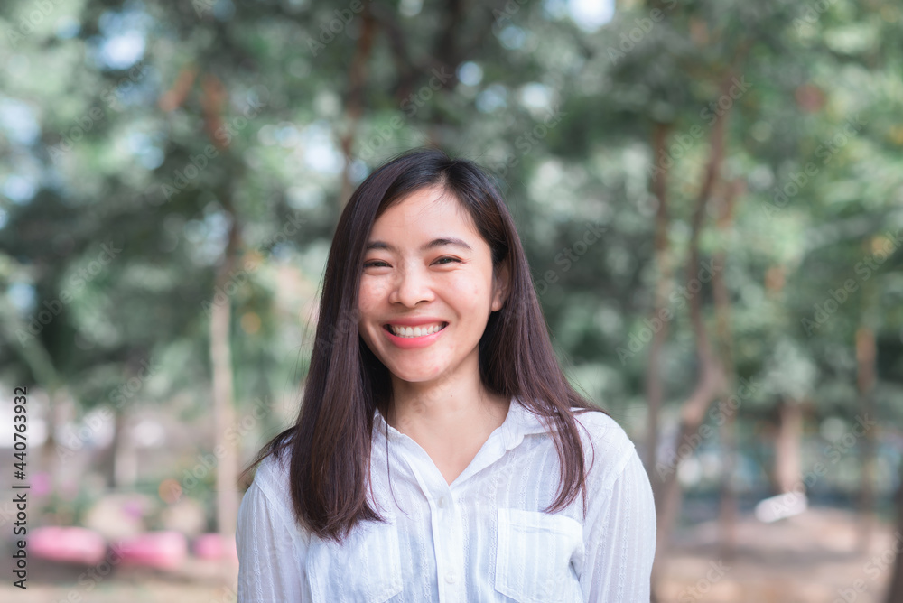 attractive adult business woman asian girl with happy and smile standing on walk way go to working between her office on morning under green forest. attractive adult business woman asian girl with happy and smile standing on walk way go to working between her office on morning under green forest.