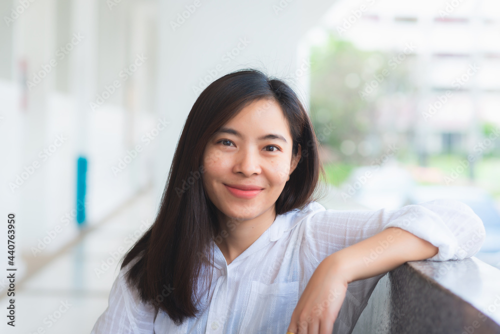 attractive adult business woman asian girl with happy and smile sitting at pole under her office on morning. attractive adult business woman asian girl with happy and smile sitting at pole under her office on morning.
