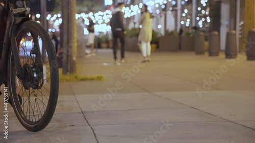 Parked bicycle and people hanging out in downtown 