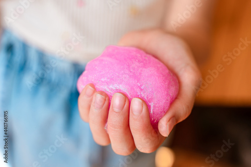 Little girl crumples in the hands of slime, children's toy, entertainment