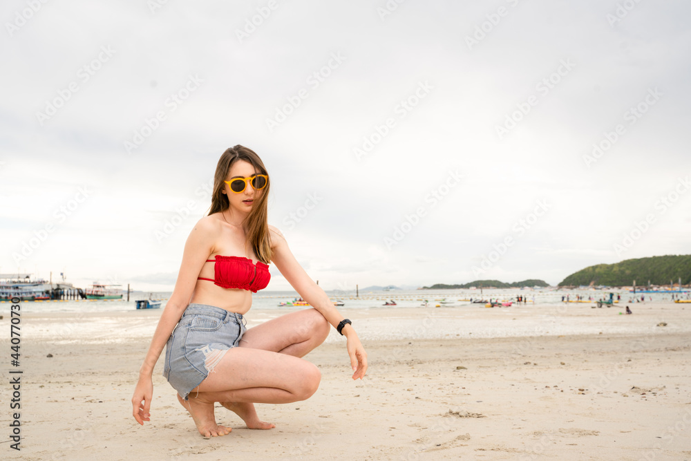 
Portrait of a 20-30 year old woman walking traveling and play marine sports on a beach by the sea in Thailand.