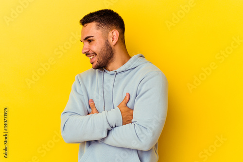Young caucasian man isolated on yellow background laughing and having fun.