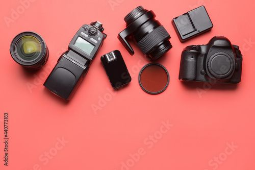 Modern photographer's equipment on color background