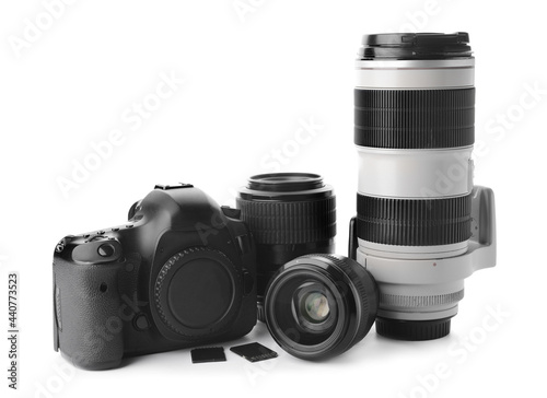 Digital camera, lenses and memory cards on white background