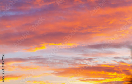 Evening sky with light orange and purple clouds at sunset