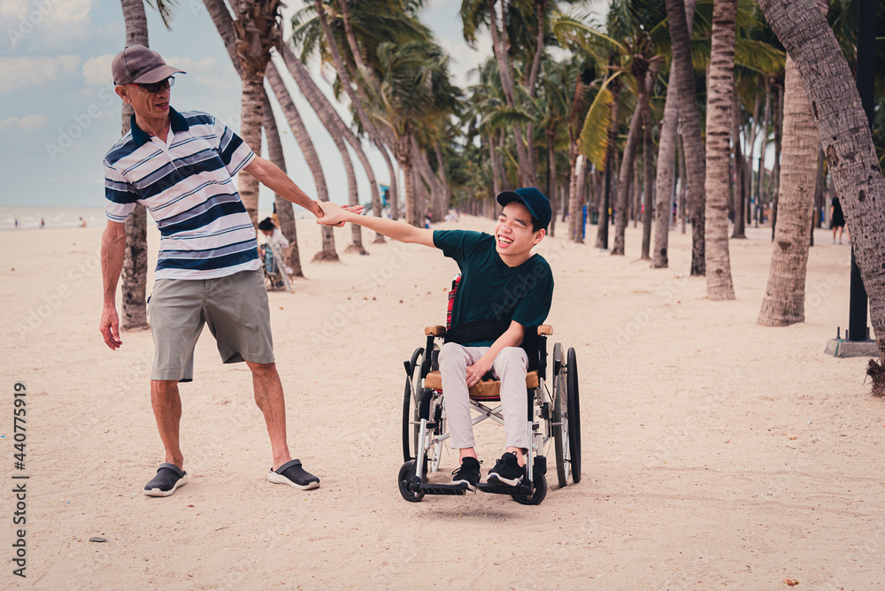 Obraz premium Father and disabled child smile face with activity outdoor on the beach, Lifestyle of disability kid travel holidays with family, Happy teenger on wheelchair.