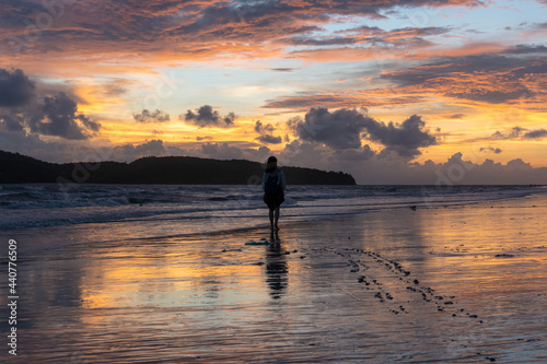 Girl walking on beach at sunset