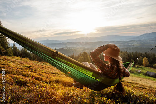 Woman hiker resting after climbing in a hammock at sunset © Maygutyak