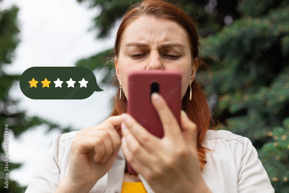 Customer Experience Concept. Close up on woman hand press on smartphone screen with gold two star rating feedback icon - obrazy, fototapety, plakaty 